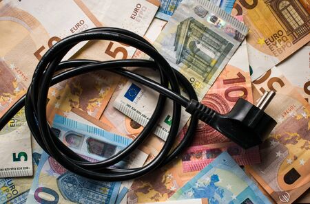 Black electric power plug on Euro paper money. Electricity cost, savings conceptの写真素材