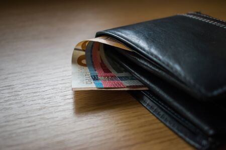 Paper money, European currency, banknotes in black wallet on wooden backgroundの写真素材