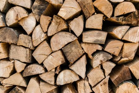 Close up neatly stacked split wood pile backgroundの写真素材