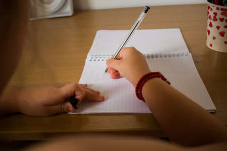 Close up of little blond girl drawing at deskの写真素材