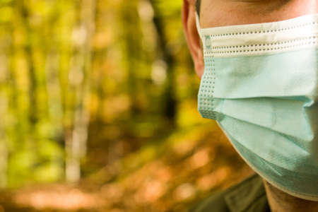 Cut out close up of man face wearing medical mask in the natureの写真素材