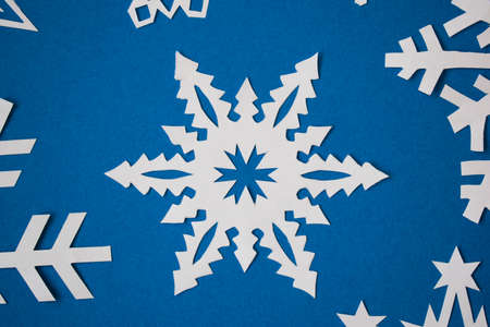Handmade paper snowflakes on blue backgroundの写真素材