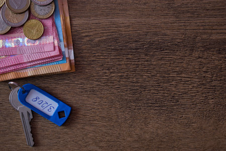 Buy, sell, rent house, apartment concept. Euro money with keys on wooden background