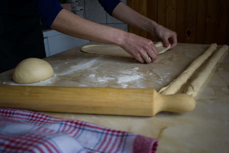 Woman female hands making preparing dough for baking on kitchen table
