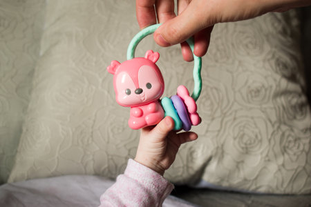 Mother gives rattle toy to baby, close upの写真素材