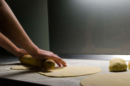 Female hands kneading with rolling pin dough for tortillasの写真素材