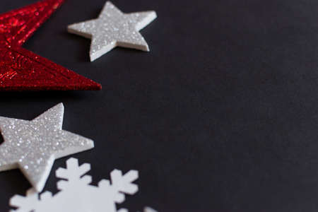 Close up of Christmas white and red stars on black background with copy spaceの写真素材