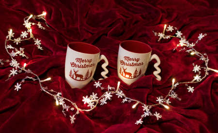Two tea cups on red fabric. Christmas concept greeting cardの写真素材