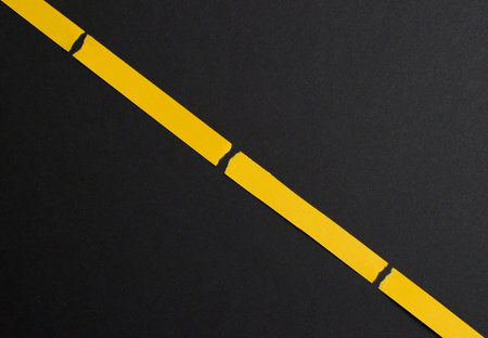 Black background diagonally divided with yellow stripes, lines