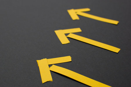 Yellow arrows on black background, close up
