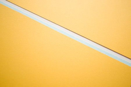 Geometric light blue and yellow divided diagonally backgroundの写真素材