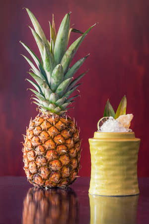 Fruit cocktail next to a pineappleの写真素材