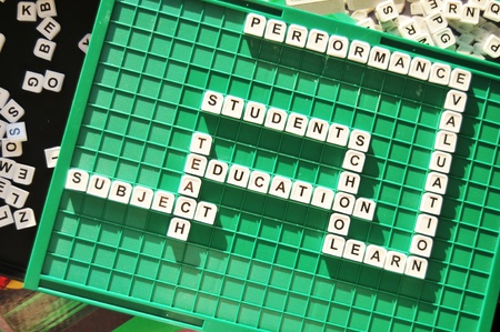 Education related crosswords on game board and hand holding a pen pointingの写真素材