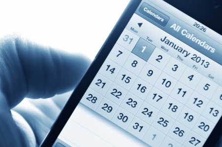 London, UK - 27 Feb, 2012: Hand holding smartphone with calendar set on 1 January 2013のeditorial素材