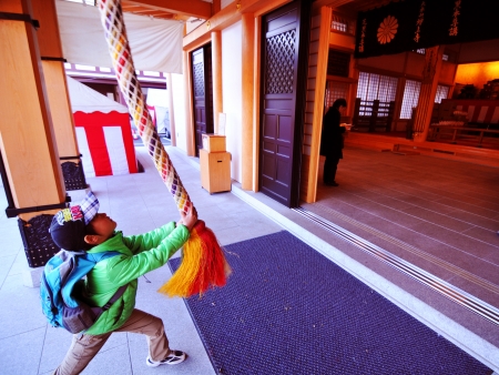 Tokyo, Japan - 29 December, 2011: Young boy rings the bell before entering buddhist temple in Roppongi, Minato districtのeditorial素材
