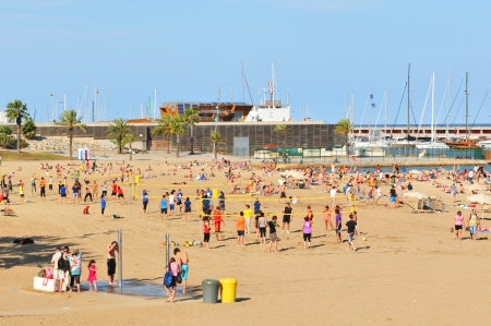 Barcelona, Spain - July 07, 2012: Crowds of tourists enjoying the sun on the beach in Barcelonaのeditorial素材
