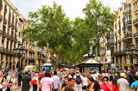 Barcelona, Spain - July 08, 2012: Crowds of tourists shopping in La Ramblas, major commercial area...