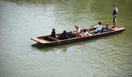 CAMBRIDGE, UK - APRIL 25, 2011: Tourists sightseeing Cambridge from gondola on river Cam