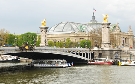 PARIS, FRANCE - MARCH 30, 2011: Tourists sighseeing Paris from cruise boat at the Alexander III bridge on Seine in Paris のeditorial素材