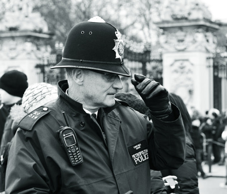 LONDON, UK - MARCH 5, 2011: London local Metropolitan policeman in uniform raises his hatのeditorial素材