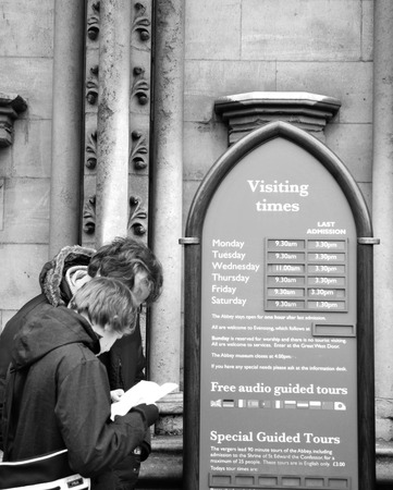 LONDON, UK - NOVEMBER 19, 2011: Tourists check visiting hours at Westminster Abbey, major tourist landmark in Londonのeditorial素材