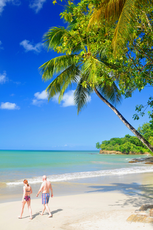 SAINT LUCIA, CARIBBEAN - DECEMBER 10, 2014: Tourists walk along the beach in exotic resort in Saint Lucia, Caribbeanのeditorial素材