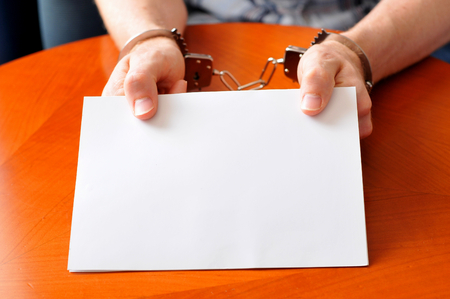 Convict with handcuffs shows blank cardの写真素材