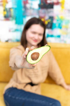 Young woman taking selfie with avocado at homeの写真素材