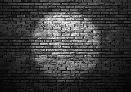 dimly lit old brick wall enlightened cone of lightの写真素材