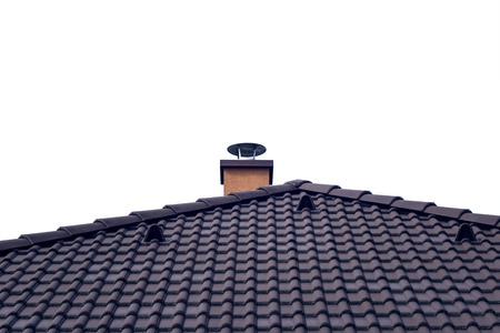 Orange chimney on tiled roof with isolated skyの写真素材