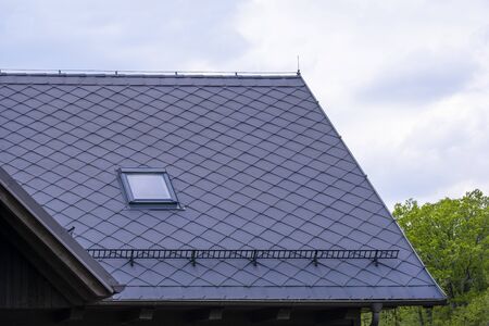 newly professionally repaired roof of a forest hut with a snow barrierの写真素材