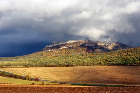 Storm clouds over a mountain with autumn colorsの写真素材