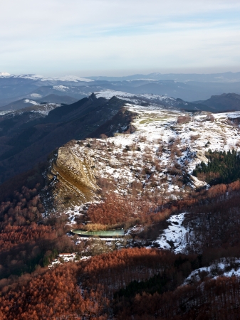 mountain range and a pond with snow and trees in Gorbeaの写真素材