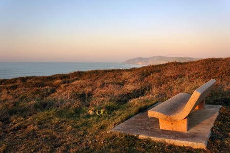 stone bench near sea at sunsetの写真素材