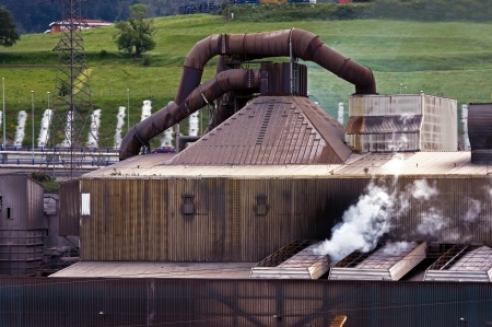 old steel factory with steam in natural environmentの写真素材