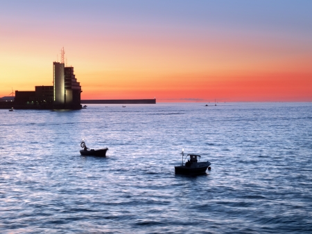 fishermen fishing at twilight on boatsの写真素材