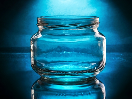 empty and open glass jar spotlightedの写真素材