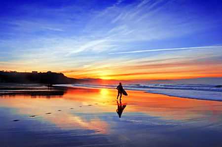 surfer in the beach at sunset