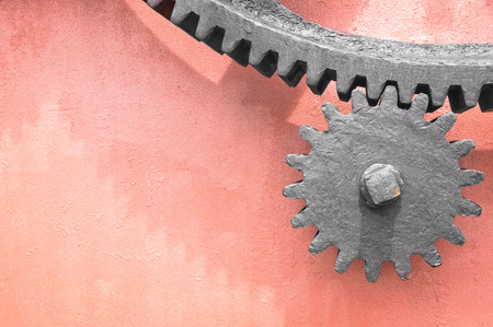 metallic gear wheel on pink wallの写真素材