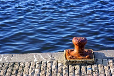 rusty bollard on port waterの写真素材