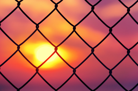 metallic fence at the sunsetの写真素材