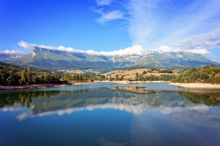 mountains in basque country with reservoir and reflectionsの写真素材