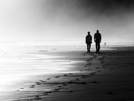 couple walking on beach. Black and white