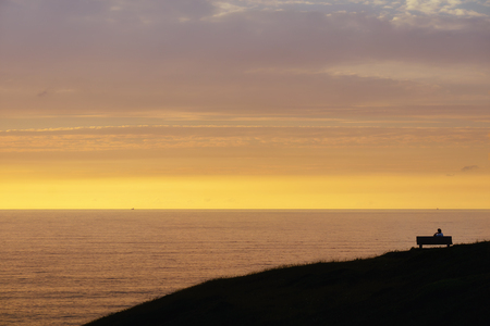lonely person contemplating the sunsetの写真素材