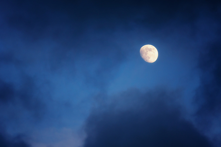 waxing gibbous moon on a cloudy skyの写真素材