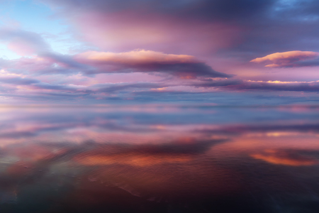 clouds with water reflections on the shoreの写真素材