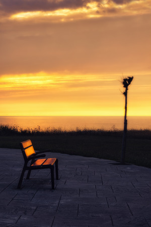 bench at sunset near the sea in Getxoの写真素材