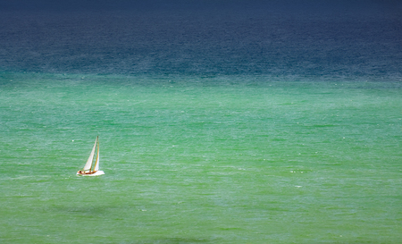 lonely sailboat on the waterの写真素材