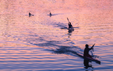 people in kayak kayaking at beautiful sunsetの写真素材