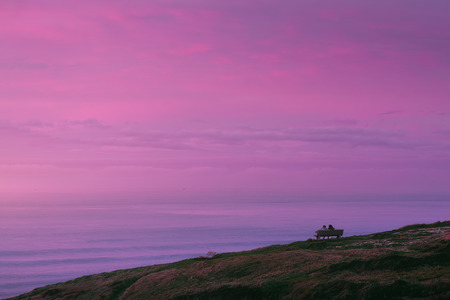 romantic view of couple watching beautiful sunsetの写真素材